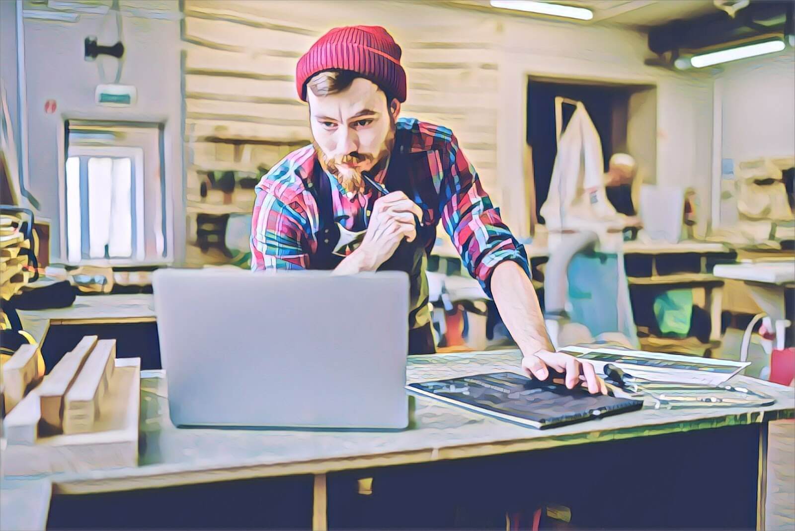 Young man using laptop in wood shop