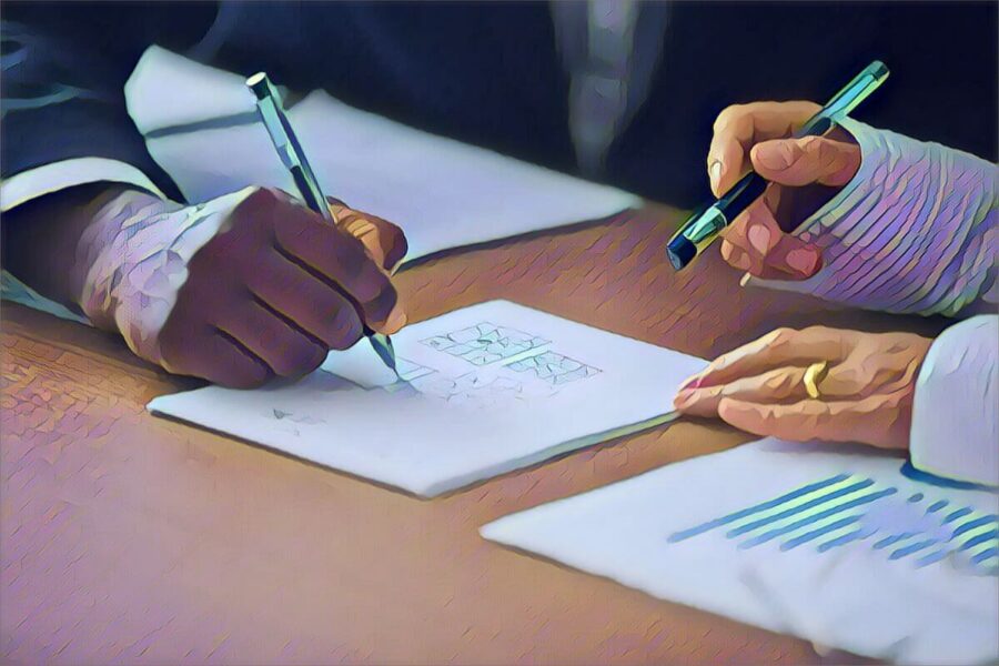 Two people analyzing handwritten notes on desk